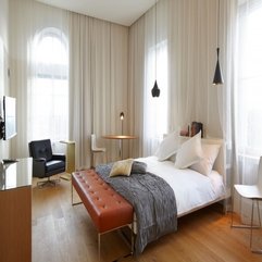 Blanket On White Bed Near Brown Pouffe In Bedroom Grey - Karbonix