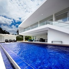 Interior Blue Infinity Pool With Wooden Floor Under Blue Sky - Karbonix